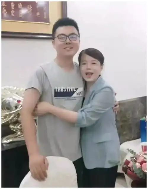 姚威搂着许敏露出开心的笑容,许敏抱着孙子,脸上表情令人难过