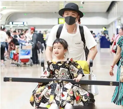 包贝尔带女儿现身机场包可艾穿图案印花裙子宛如公主表情呆萌